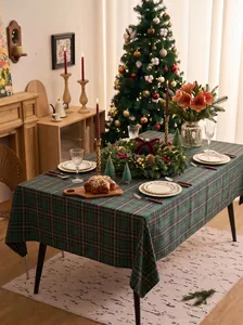 Festive green and red plaid tablecloth set on a Christmas decorated dining table.
