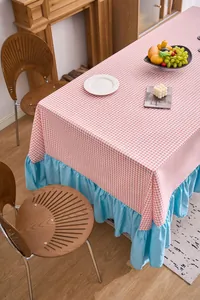 Dettaglio di tovaglia a quadretti rosa con elegante bordo a balze blu stile rustico