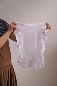 Gedetailleerde weergave van een wit katoenen linnen placemat met ruches voor de tafel