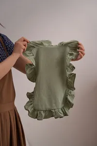 Hand-held weergave van een saliegroene katoenen linnen placemat met ruches