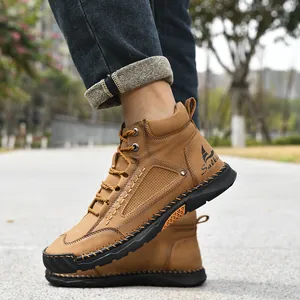 Close-up of men's brown PU leather ankle boots with hand-stitched detailing outdoors