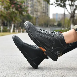 Detailed view of men's black PU leather ankle boots featuring hand-stitched accents.