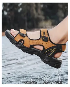Dynamic outdoor action shot of men's tan leather sandals with water splashing effect