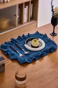 Gedetailleerd overzicht van een donkerblauwe katoen-linnen placemat met ruches randen