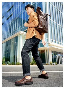 Asian male model wearing vintage brown leather loafers walking on an urban street