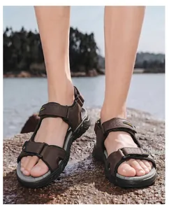 Detail shot of brown leather men's outdoor beach sandals worn on a rocky shore