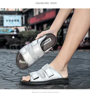 Close-up of white leisure mesh sandals with adjustable velcro straps on a street background