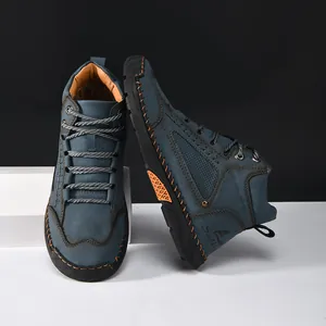 Close-up detail of blue men's PU leather ankle boots with orange hand-stitched seams.
