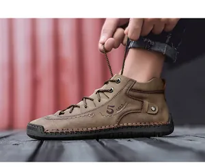 Nahaufnahme einer Person, die handgefertigte braune Lederstiefel für Herren schnürt.