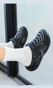 Gros plan de sabots noirs pour hommes avec trous d'aération et texture ondulée