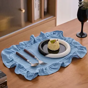 Elegante lichtblauwe katoenen linnen placemat met ruches op een houten tafel