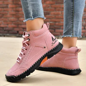 Detail of pink PU leather ankle boots with decorative hand-stitched black rubber soles.