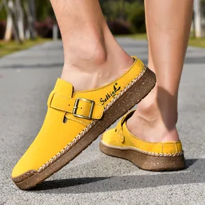 Side view detail of yellow suede mule loafers with buckle and white hand-stitching
