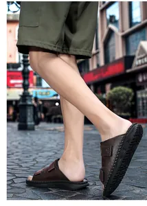 Close-up view of large size men's brown leather sandals with adjustable velcro straps