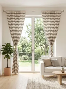 Elegant French striped green sheer curtains with decorative tassels in a sunlit living room