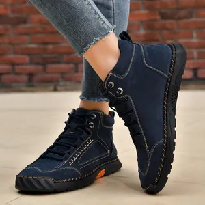 Close-up of men's navy blue PU leather ankle boots with detailed handmade stitching.