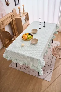 Detalle de un mantel retro de cuadros verdes con bordes de volantes en un comedor rústico