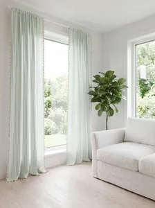 Light green striped curtains with tassel trim in a bright, modern living room setting.