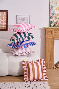 Macro view of striped cushion covers with ruffled edges in a modern living room.