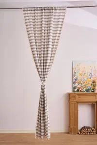 Light French style striped sheer curtain with elegant tassel trim hanging in a cozy room