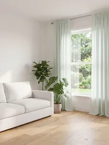 Light green French striped sheer curtains with elegant tassel trim in a living room