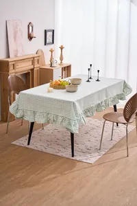 Mantel de cuadros verde salvia con bordes de volantes en un ambiente de comedor acogedor.
