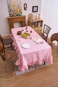 Detailed view of a pink and white striped ruffled tablecloth on a styled dining table