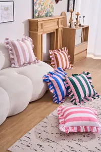 Selection of colorful ruffled stripe cushion covers displayed on a sofa in a modern home