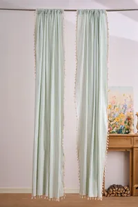 Detailed view of light green and white striped curtains with elegant cream fringe tassels.