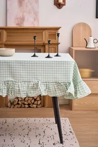 Primer plano de mantel de cuadros verdes y blancos con detalle de borde con volantes.