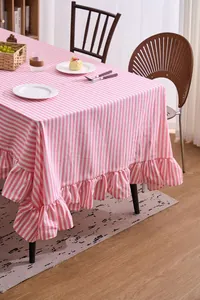 Pink and white striped tablecloth with ruffled edges in a warm home dining setting