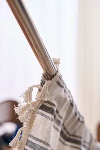 Close-up detail of a striped French style curtain showing tassel trim and fabric texture
