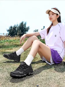 Close-up view of durable black hiking shoes for women worn on a grassy outdoor trail