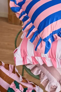 Close-up of ruffled striped Dutch velvet pillowcases in vibrant multi-color patterns