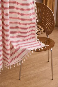 Dettaglio della tenda a righe rosse e bianche con nappe bohémien e trama in cotone