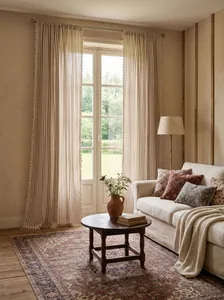Cortinas de rayas caqui de estilo francés con borlas en una acogedora sala de estar.
