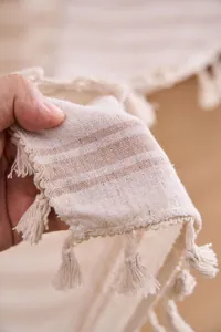 Detailaufnahme eines gestreiften Vorhangstoffs mit eleganten Quastenverzierungen