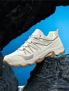 Detailed view of durable beige outdoor hiking shoes on a rugged rock background