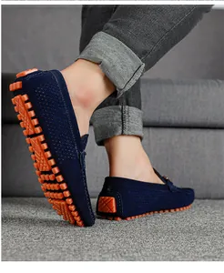Primer plano de mocasines de ante azul para hombre con suelas de goma naranja