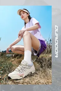 Asian woman wearing beige and pink outdoor hiking shoes in a sunny mountain landscape view