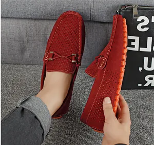 Primer plano de mocasines de cuero rojo perforado con diseño transpirable y suela goma.