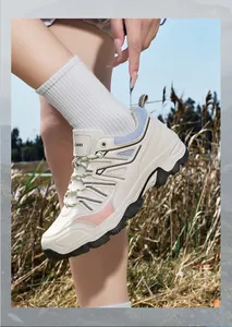 Close-up shot of stylish beige and pink outdoor hiking shoes worn by a female model