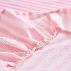 Soft pink and white striped tablecloth with ruffle details for home decor.