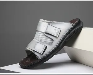 Detailed close-up view of grey leather casual slides with adjustable dual velcro straps