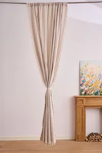 Cortina a rayas de estilo francés con borlas en una acogedora decoración de sala de estar.