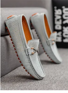 Elegantes mocasines calados para hombre con llamativas suelas de goma naranja