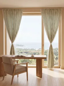 Cortinas de rayas verdes de estilo francés con borlas en un entorno de ventana soleada.