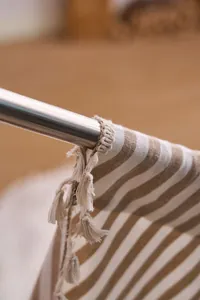 Detalle macro de cortina de rayas caqui de estilo francés con elegante borde de borlas