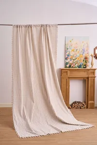 Elegante cortina traslúcida de rayas caqui con borlas decorativas en una habitación