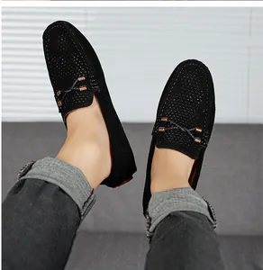 Detalle de los mocasines negros perforados para hombre con correa decorativa y hebillas metálicas